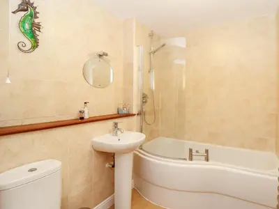 a bathroom with a sink and a tub and a toilet at Ocean Blue in Penzance