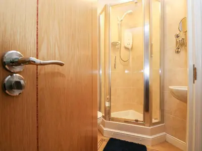 a bathroom with a shower and a glass door at Ocean Blue in Penzance