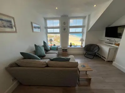 a living room with two couches and a television at Trevose in St Ives