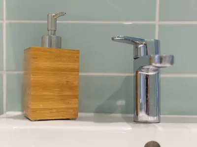 a bathroom sink with two faucets and a wooden block at Trevose in St Ives