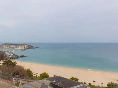 a view of a beach with houses and the ocean at Trevose in St Ives