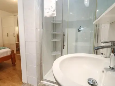 a white bathroom with a shower and a sink at Tremar in St Ives