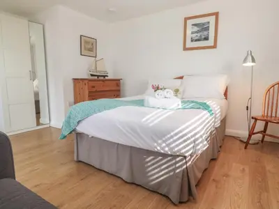 a bedroom with a bed with a teddy bear on it at Tremar in St Ives