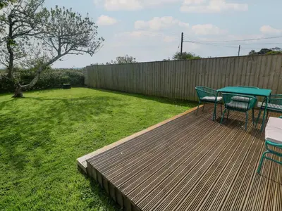 a wooden deck with a table and chairs on it at Tremar in St Ives
