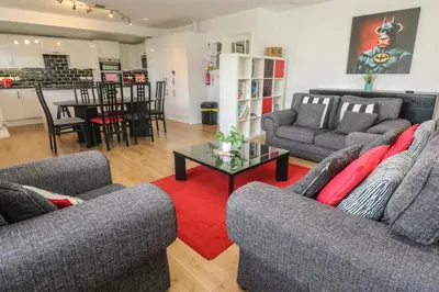 a living room with two couches and a red rug at Tremar in St Ives