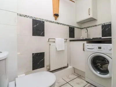 a bathroom with a washing machine and a washer at Tremar in St Ives