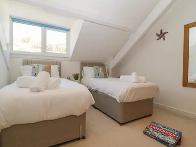 two beds in a attic room with two windows at Ocean View in Marazion