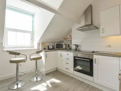 a kitchen with white cabinets and a stove top oven at Ocean View in Marazion