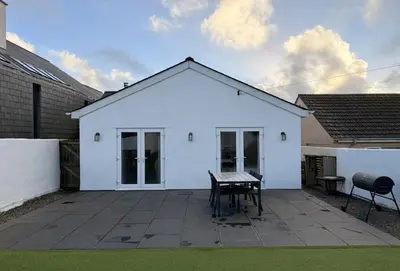 a white house with a table on a patio at Miss Fishers in Port Isaac