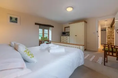 a bedroom with a large white bed with pillows at Spring Barn in Polzeath