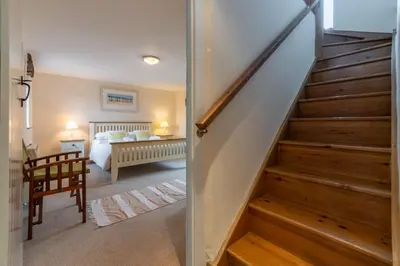 a hallway with stairs leading to a bedroom at Spring Barn in Polzeath