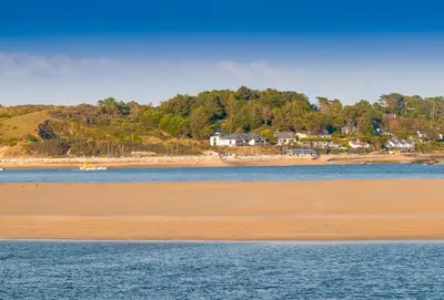 a view of a beach with houses on a hill at Spring Barn in Polzeath