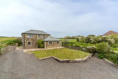 an estate with a large garden in front of a house at Spring Barn in Polzeath