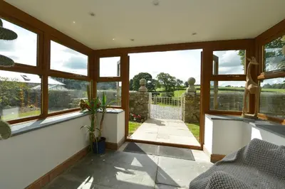 a room with windows and a view of a garden at Haye Barton Farm in Liskeard