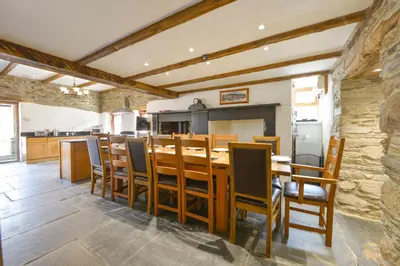 a dining room with a wooden table and chairs at Haye Barton Farm in Liskeard