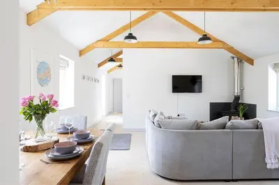 a living room with a couch and a table at Cart Shed Cottage in Truro