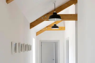 a hallway with white walls and a ceiling with beams at Cart Shed Cottage in Truro