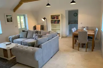 a living room with a couch and a table at Cart Shed Cottage in Truro