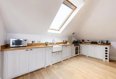 a kitchen with white cabinets and a window at 9 Fernhill Penthouse in Carbis Bay