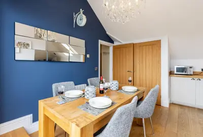 a dining room with a wooden table and chairs at 9 Fernhill Penthouse in Carbis Bay