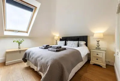 a bedroom with a bed and a window at 9 Fernhill Penthouse in Carbis Bay