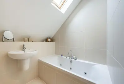 a white bathroom with a sink and a bath tub at 9 Fernhill Penthouse in Carbis Bay