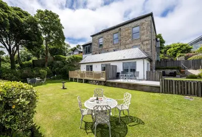 a table and chairs in the yard of a house at 9 Fernhill Penthouse in Carbis Bay