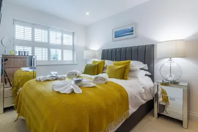 a bedroom with a yellow bed with towels on it at 5 Four Seasons in Carbis Bay