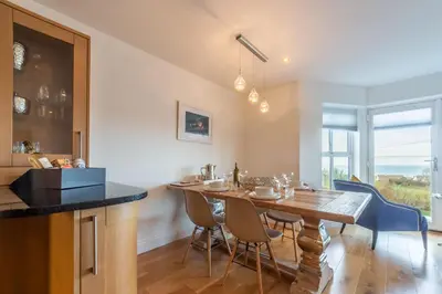 a kitchen and dining room with a wooden table and chairs at 5 Four Seasons in Carbis Bay