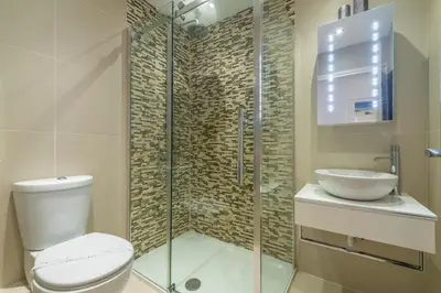 a bathroom with a glass shower with a toilet and a sink at 5 Four Seasons in Carbis Bay