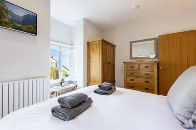 a bedroom with a white bed with towels on it at 5 Fernhill in Carbis Bay