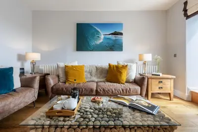 a living room with a couch and a large wave at 5 Fernhill in Carbis Bay