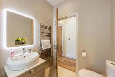 a bathroom with a sink and a toilet and a mirror at 5 Fernhill in Carbis Bay