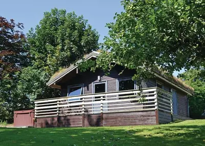 a small house on a field with a tree at Avallon Lodges in Launceston