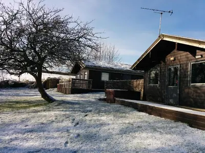 a house with snow on the ground next to a tree at Avallon Lodges in Launceston