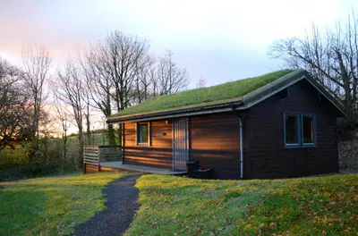 a small cabin with a grass roof on a hill at Avallon Lodges in Launceston