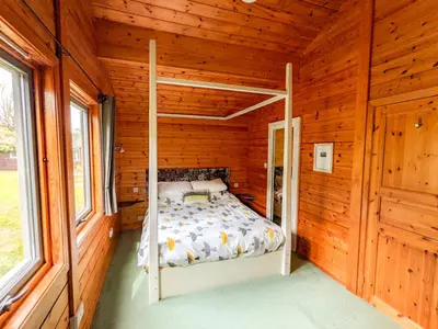 a bedroom with a bed in a wooden cabin at Avallon Lodges in Launceston