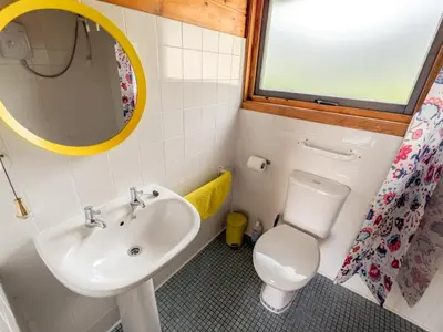 a bathroom with a sink and a toilet and a mirror at Avallon Lodges in Launceston