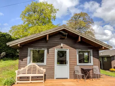 a small house with a white door and a table and chairs at Avallon Lodges in Launceston