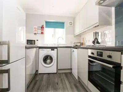 a white kitchen with a washer and dryer at Compass Point in Falmouth