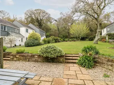 a yard with a stone retaining wall and a park at Compass Point in Falmouth