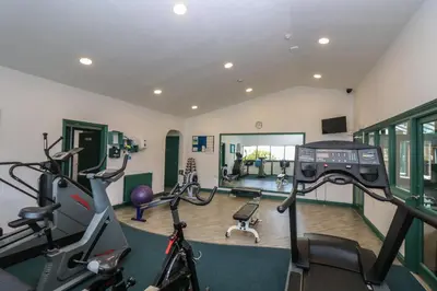 a gym with cardio equipment and bikes in a room at Compass Point in Falmouth