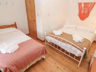 two twin beds in a room with wooden floors at Kernyk in Helston
