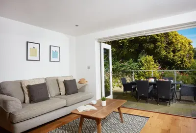 a living room with a couch and a table at 3 Sandy Lane in Carbis Bay