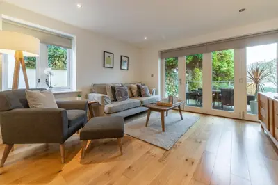 a living room with a couch and a table at 3 Sandy Lane in Carbis Bay