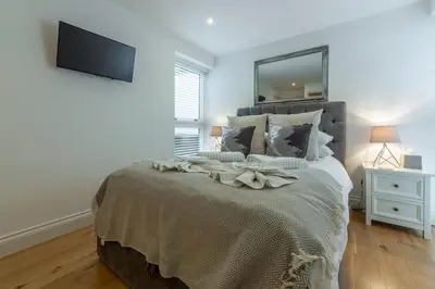 a bedroom with a bed with a tv on the wall at 3 Sandy Lane in Carbis Bay