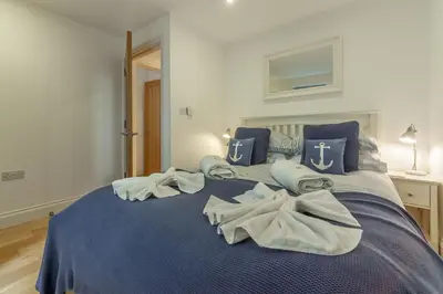 a blue bed with towels on it in a room at 3 Sandy Lane in Carbis Bay