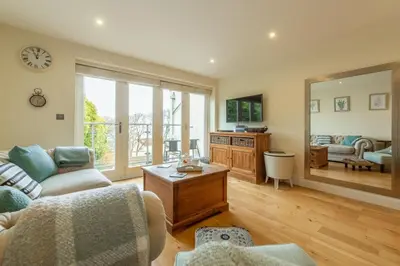 a living room with a couch and a table at 6 Sandy Lane in Carbis Bay