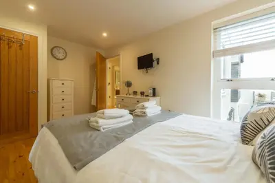 a bedroom with a large bed with towels on it at 6 Sandy Lane in Carbis Bay