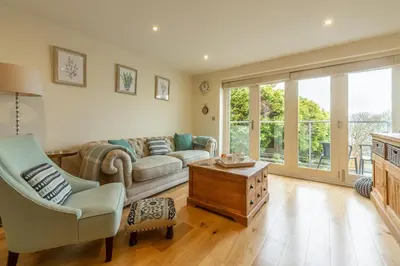 a living room with a couch and a table at 6 Sandy Lane in Carbis Bay
